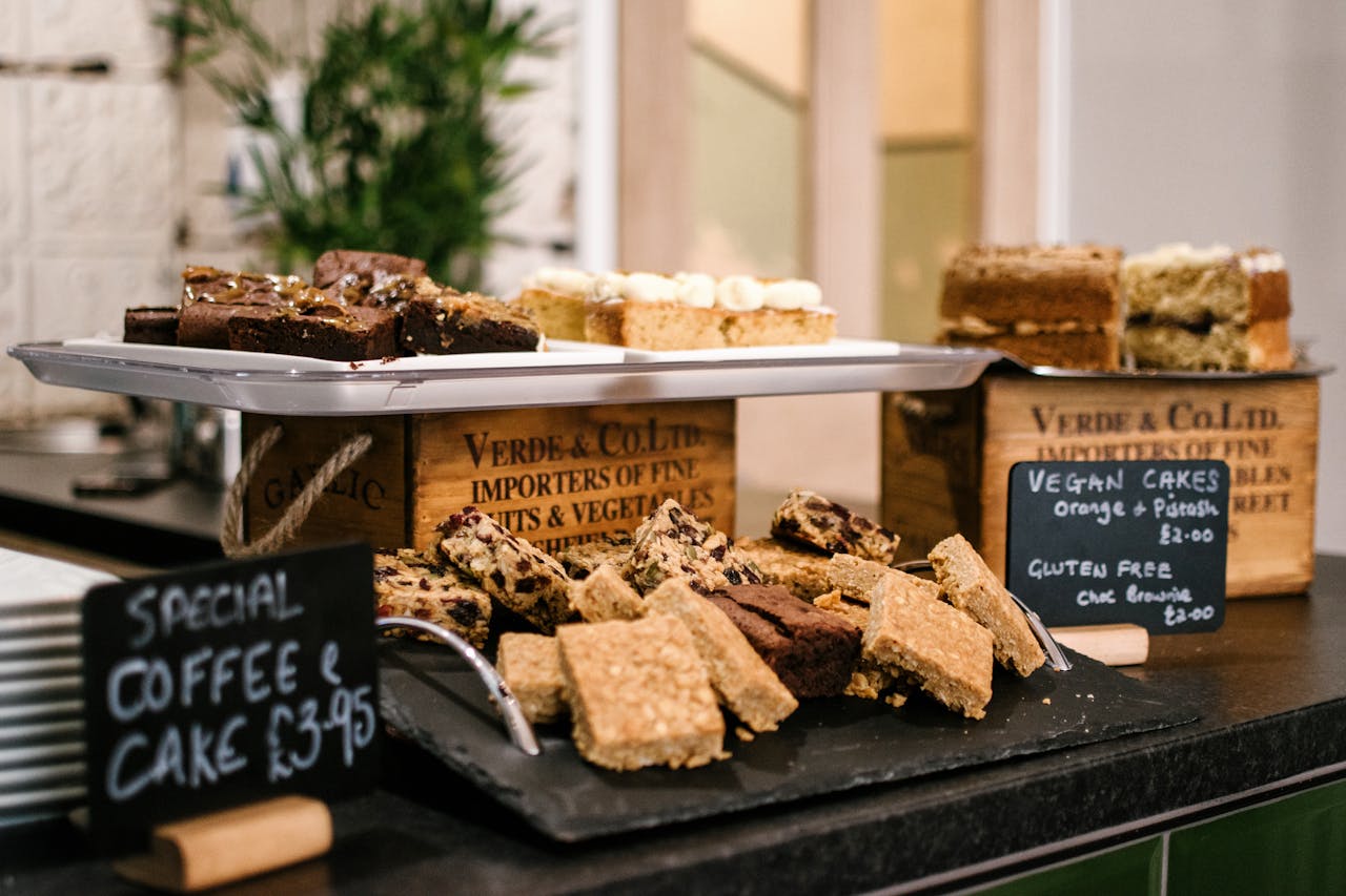 Assortment of vegan and gluten-free cakes on display at a cafe. Perfect for indulgence.