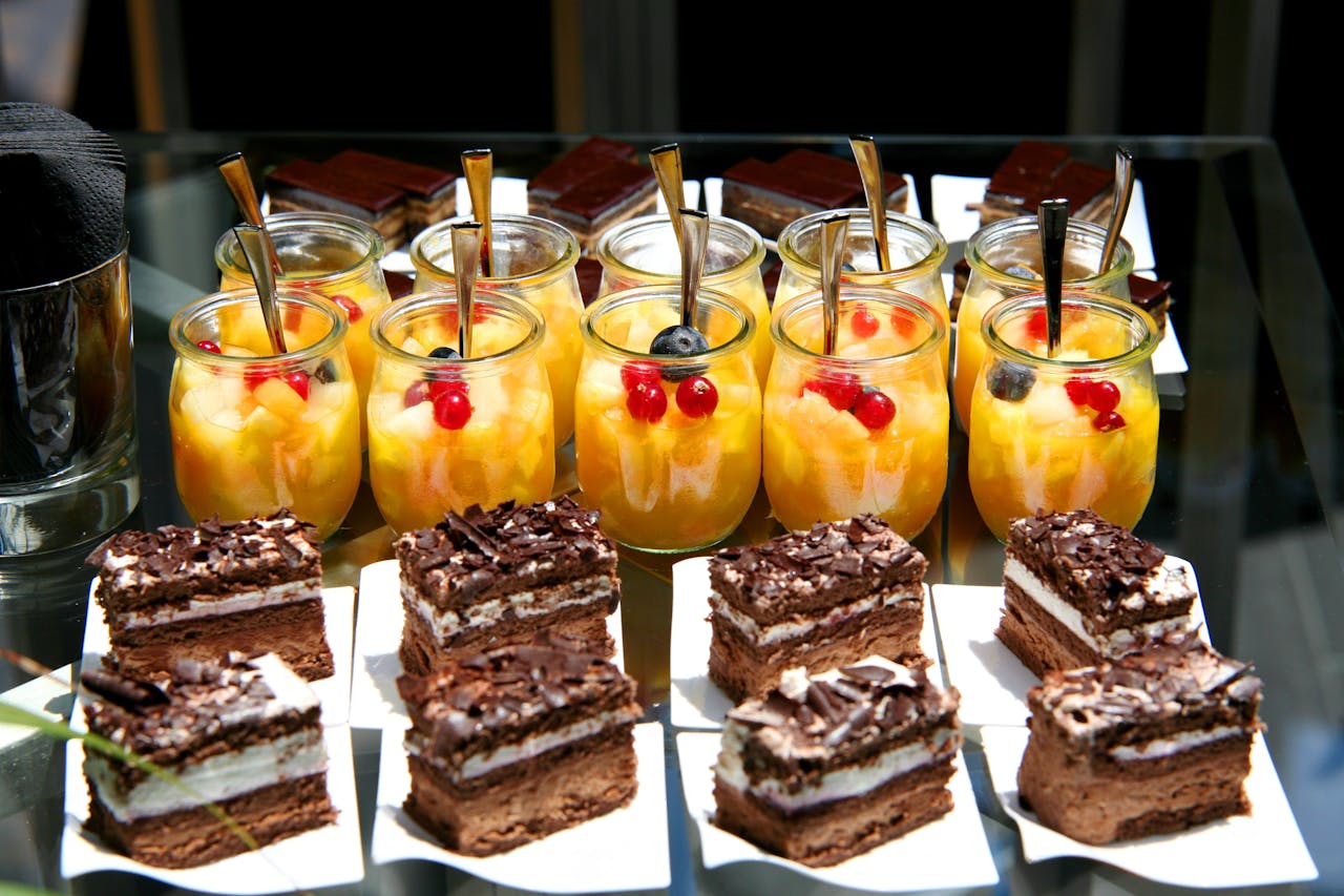 Enticing dessert table featuring fruit salad jars and chocolate cakes, perfect for celebrations.